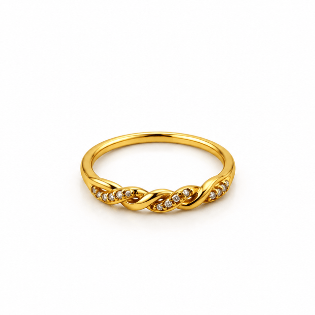 Gold-tone ring with a slender band, flowing interlacing wave pattern and small clear reflective accents, displayed on a white background and worn on a finger. - bhavmayi