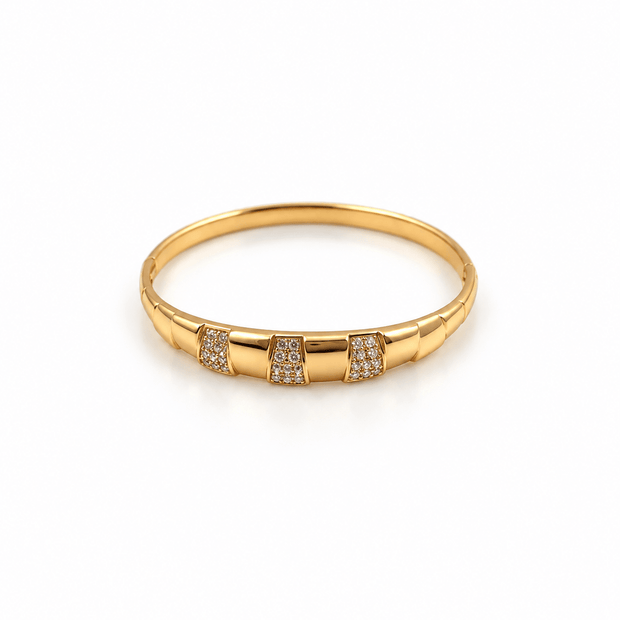 Golden bangle with three rectangular embellished panels and clear white accent detailing