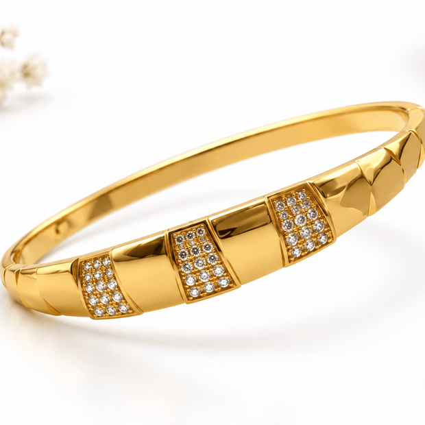 Golden bangle with three rectangular embellished panels and clear white accent detailing