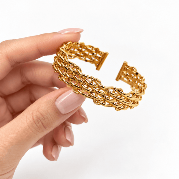 Golden cuff bracelet featuring layered interwoven links and an open mesh-style design