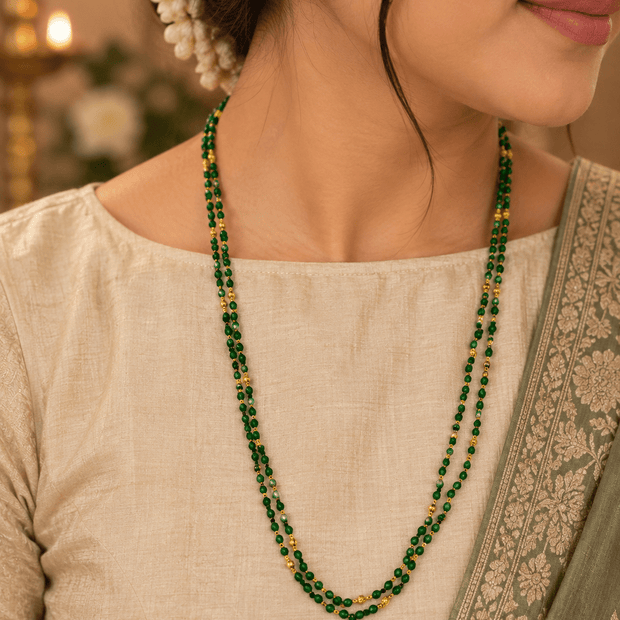 Double strand necklace featuring deep-green round beads, spaced gold-tone accents, displayed on a white background.