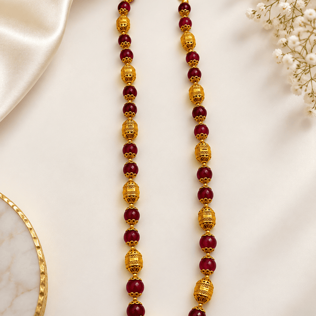 Bhavmayi maroon bead necklace with ornate gold-tone spherical accents and matching jhumka earrings.