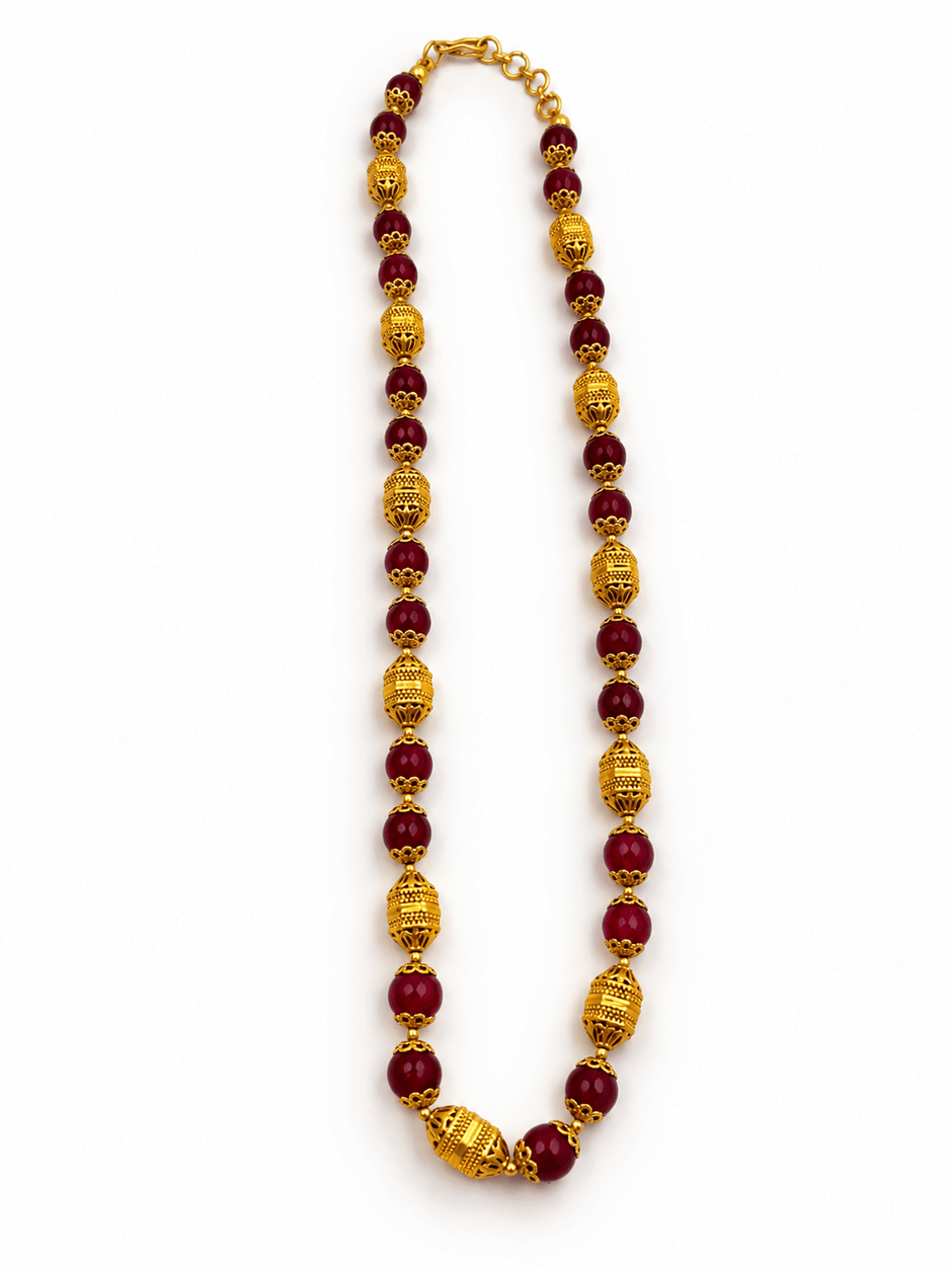 Long maroon beaded necklace with glossy rounded beads, ornate gold-tone barrel-shaped beads, floral-style bead caps and a hook-style clasp, shown from two angles. - bhavmayi