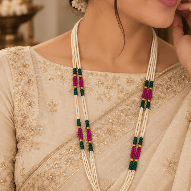 Bhavmayi triple-strand necklace with ivory-white beads, dark green and magenta-pink bead clusters, and gold-tone.