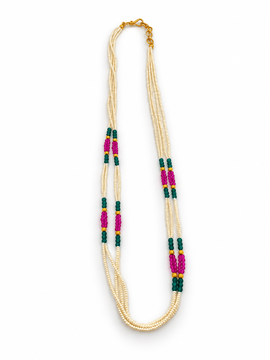 Long multistrand ivory-white pearl-style necklace featuring round gold-tone beads, green and magenta bead sections, and a gold-tone hook clasp, shown from two angles. - bhavmayi