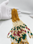 Long multistrand ivory-white pearl-style necklace featuring round gold-tone beads, green and magenta bead sections, and a gold-tone hook clasp, shown from two angles. - bhavmayi