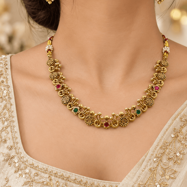 Bhavmayi traditional golden-toned necklace and matching earrings with floral motifs and red and green accent details